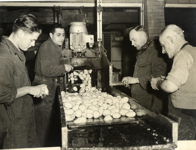 405276 Afbeelding van enkele mannen bij de aardappelschilmachine in de Centrale Keuken van de Gemeentelijke ...